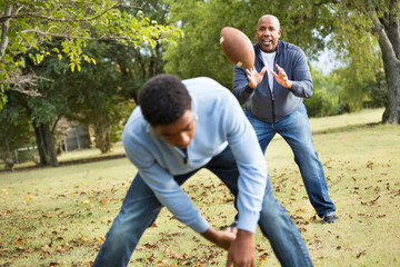 African American Father Playing 
Football With His Son.