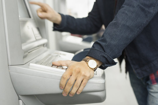 Midsection of man using ticket machine at railroad station