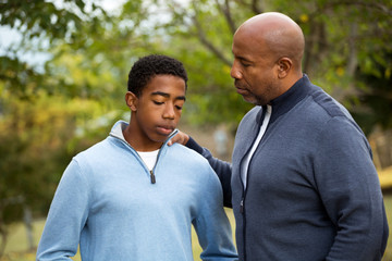 African American father and son in deep conversation. - Powered by Adobe