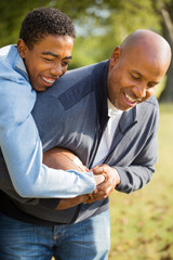 African American Father Playing 
Football With His Son.