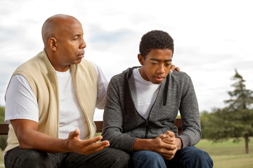 African American father and son in deep conversation.