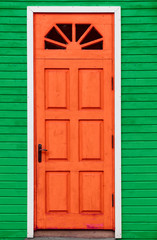 Red vintage wooden door and green wall