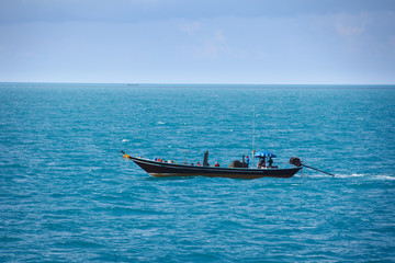 Obraz premium Old fishing boat goes by sea - fishermen working