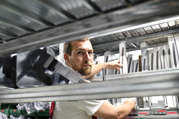 Arbeiter in einem Warenlager - Closeup zwischen Regalen // workers in a warehouse - closeup between...