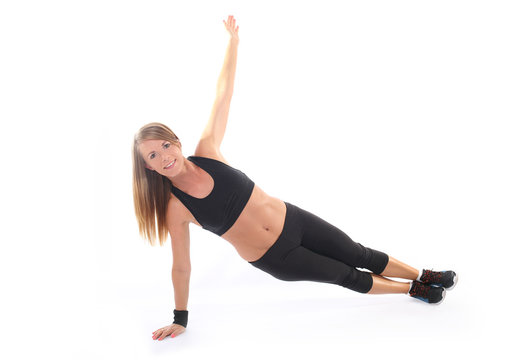 Athletic young woman practicing plank on white baclgr
