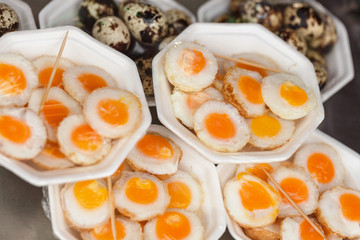 Scrambled quail eggs and boiled eggs at market