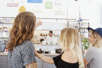 Happy friends deciding menu at restaurant