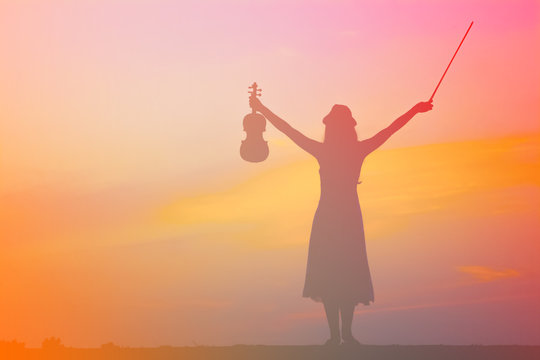 The silhouette of asian woman with the violin with colorful filt