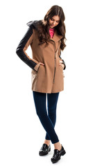 Woman in coat looks down. Pants and coat with inserts. Brand new autumn shoes. Apparel from top quality materials.