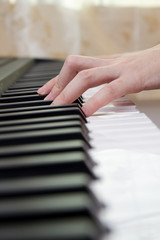 Fototapeta na wymiar Girl's hands on the keyboard of the piano