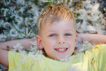 Portrait of a little boy who is lying on the grass covered with