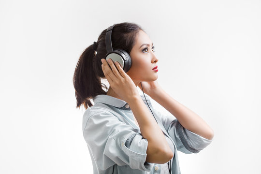 Young beautiful woman enjoy listening to music with big headphones isolated white background