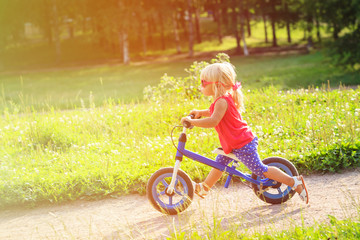 Fototapeta premium cute little girl riding runbike in summer