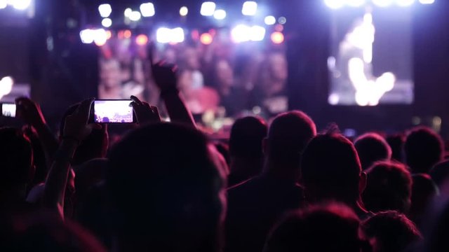 Euphoric crowd recording concert with smartphone