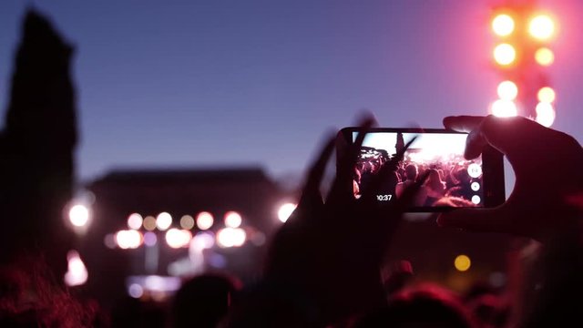 Hands recording video with smart phones at music concert