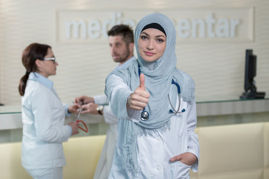 Happy smiling cheerful female muslim doctor with thumbs up gesture