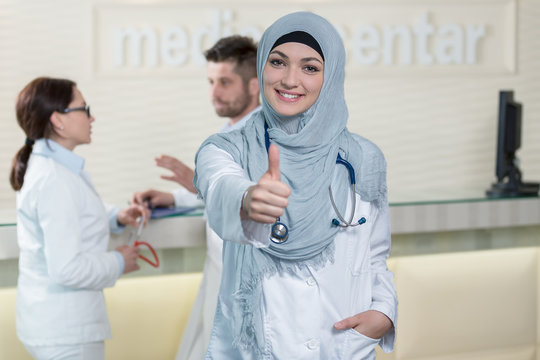 Happy smiling cheerful female muslim doctor with thumbs up gesture