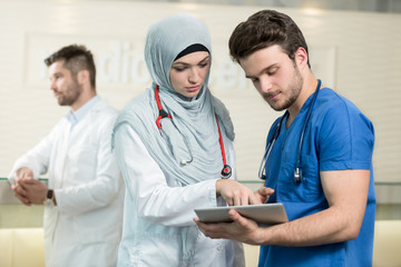 Saudi arab doctors working with a tablet.
