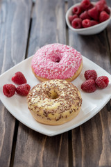Ripe tasty raspberries and donuts on wooden background.Selective focus
