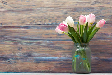 Colorful tulips flowers on wooden table. Top view with copy space. Toned picture by instagram filter