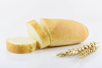 Sliced baguette and wheat ear on a white background