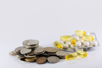 coins and pills on white background. The increase in drug prices