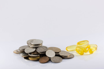 coins and pills on white background. The increase in drug prices