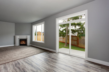 Fototapeta premium Grey living room interior. Windows and Glass doors overlooking the back yard.