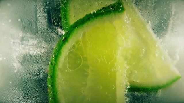 Cold cocktail with lime, tonic and ice, closeup