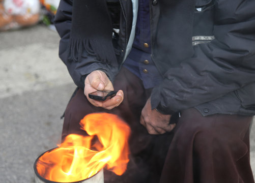 poor man in the street using a mobile phone and heats up