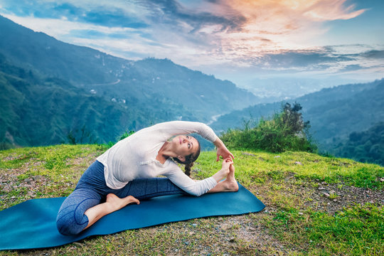 Young sporty fit woman doing Hatha Yoga asana in mountains