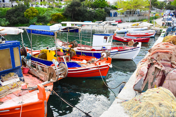 Traditional Greek fishing harbour with boats white houses by the