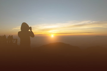 Silhouette of a woman photographed the sunrise.