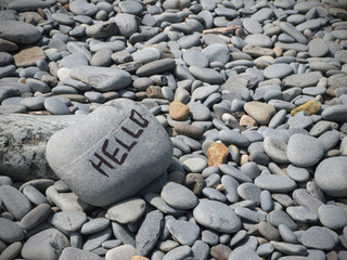 Hello writing on pebbled beach