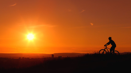 Fototapeta na wymiar A cyclist enjoys a picturesque sunset.