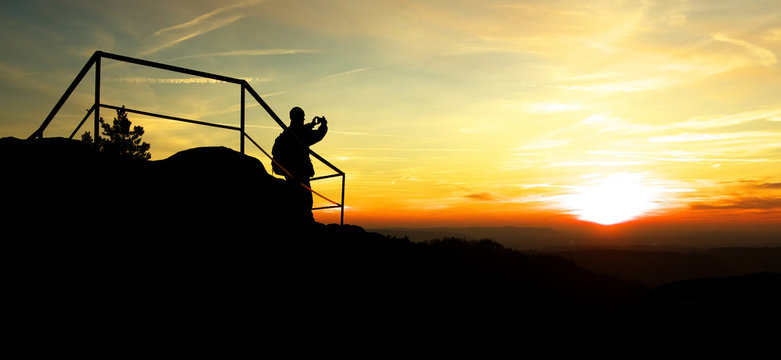 Silhouette of Man Taking Photo of Sunset