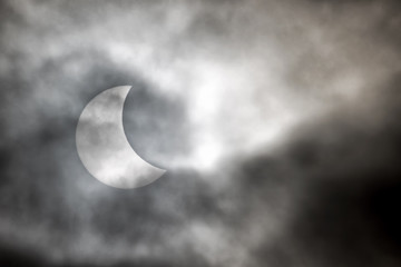 Obraz na płótnie Canvas Solar eclipse through the clouds.