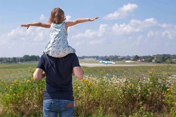 Dad and daughter watching as the plane prepares for takeoff