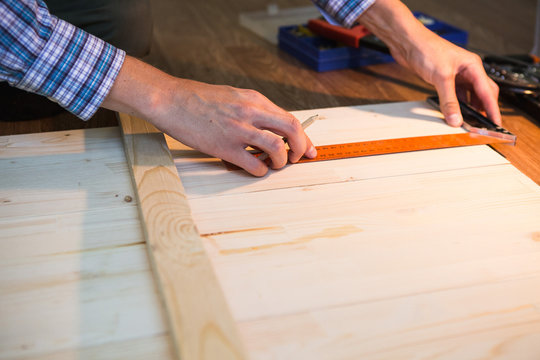 
man sawing a board