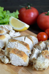 chicken fillet baked with rosemary on wooden board with vegetables