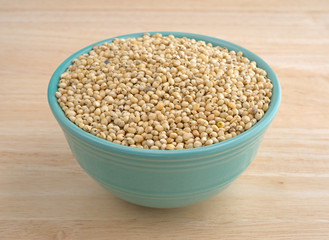 Whole grain sorghum seeds in a bowl on a table.