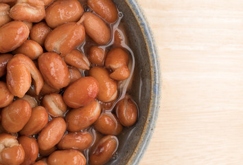 Bowl of shelled beans on a wood table top close view.