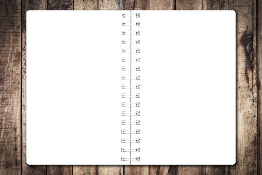 Open notebook paper on wood background for design with copy space for text or image.