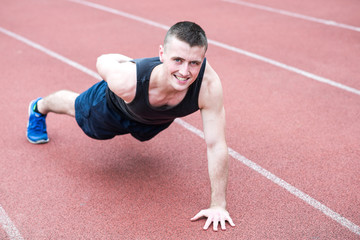Handsome fit man exercising push up one hand