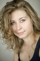 a pretty blonde with cute curls on a gray background. a good day