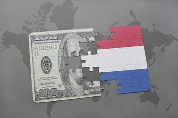 puzzle with the national flag of netherlands and dollar banknote on a world map background.