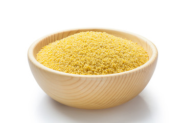 Fresh organic millet in a wooden bowl on white background