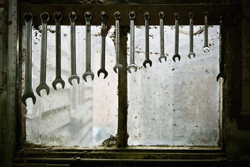 A tool rack with spanners of varying sizes hanging up in order. 