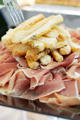 Prosciutto, traditional italian cured ham with slices of bread