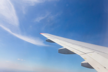 View from airplane window with blue sky and white clouds